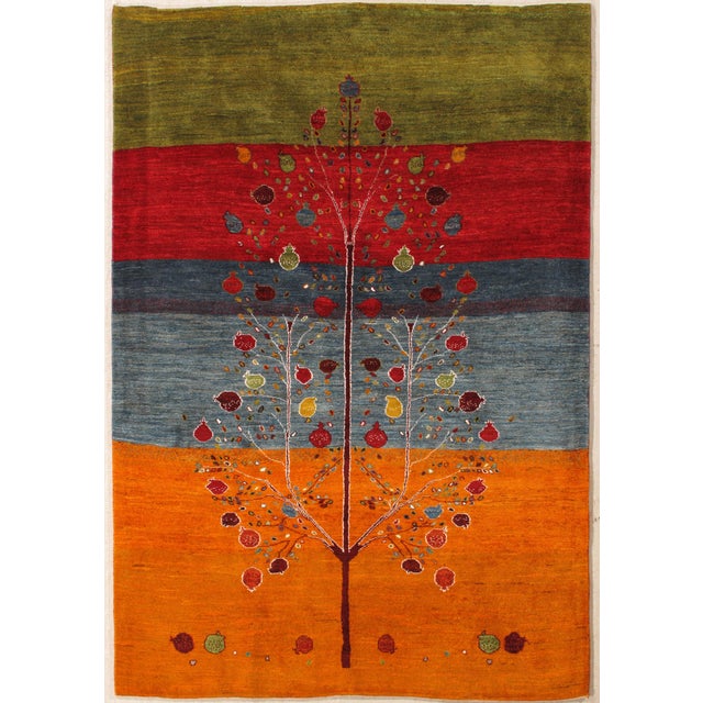 Vintage Hand-knotted Persian Gabbeh rug featuring a field composed of horizontal bands in green, red, blue, and orange,...