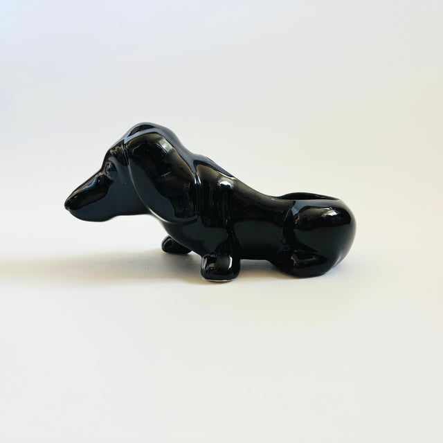 A mid century vintage ceramic planter in the shape of a dachshund. Glossy black finish. Lovely simplified design.