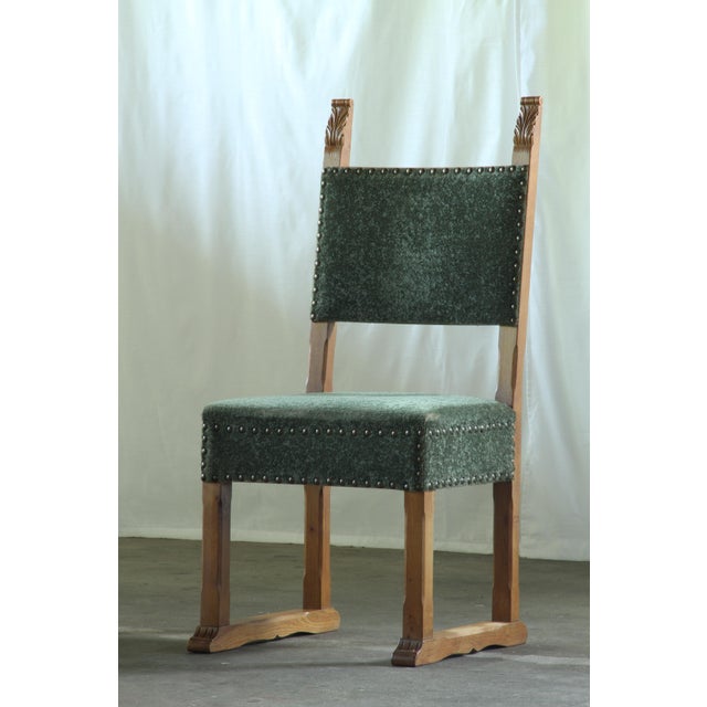 A rare set of four heavy, solid oak chairs made in Denmark in the 1950s. Handwritten in pencil beneath two of the chairs...