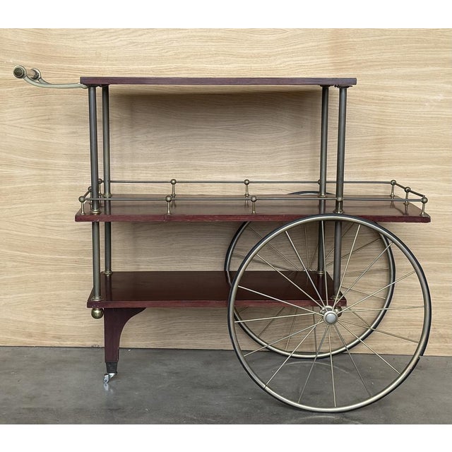 Unique mid-century bar cart in mahogany wood , brass and acrylic handle. This fantastic item was designed in Italy during...