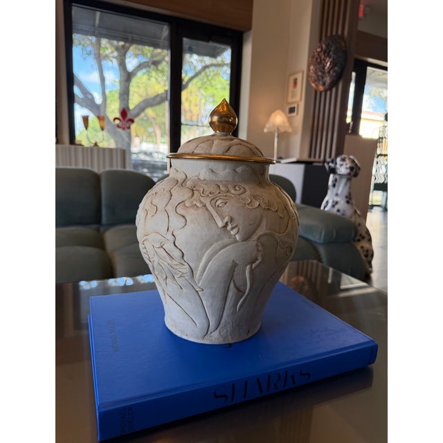 In the Sevres Style French Art Deco lidded urn crafted from porcelain bisque. It is notable for its intricate, high-relief...