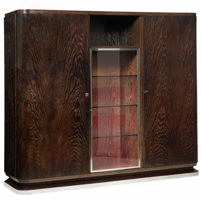 ART DECO CERUSED AND EBONIZED OAK DISPLAY CABINET WITH FLANKING BLIND BOOKSHELVES Probably German, as the locks are of...