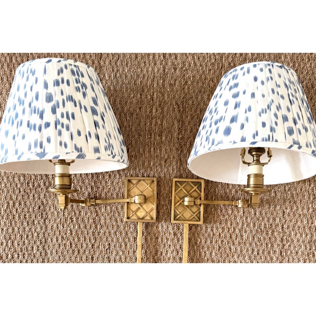 Pair of brass Alexa Hampton "Gene" swing arm wall sconces. Made by Visual Comfort. Includes custom Brunschwig and Fils...
