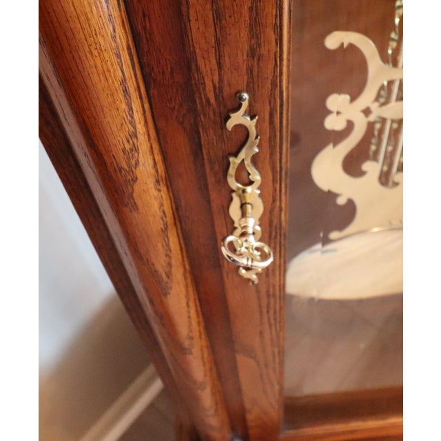 A distinguished Howard Miller “Charlemagne” floor clock (Model 610-361), crafted in richly figured oak and featuring one...