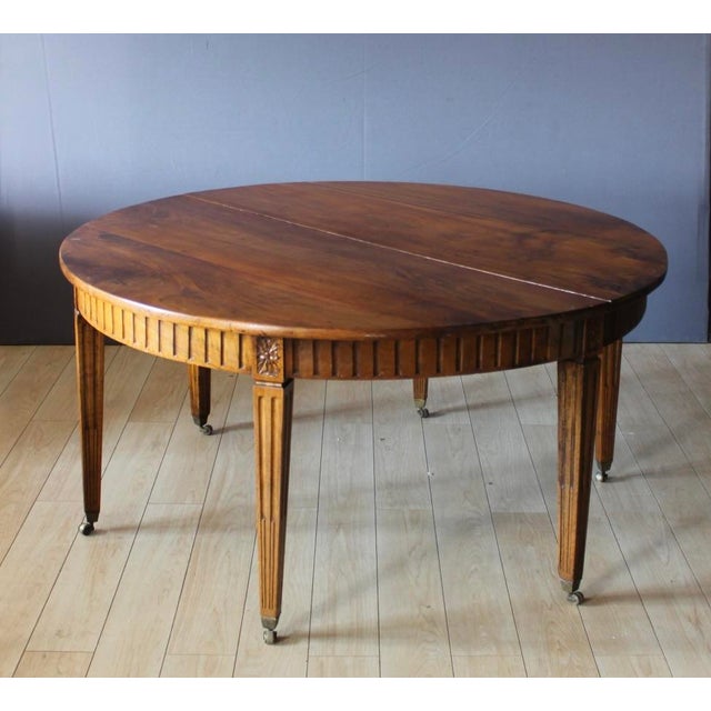Large Louis XVI style extendable table in solid walnut, with three 50cm leaves, 305cm long when open, six legs, 61cm high...