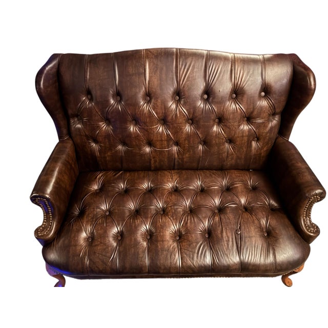 Command attention with this stately Vintage English Chesterfield Wingback Settee, a rare find in a "loveseat" scale. This...