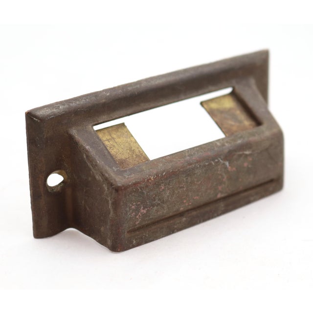 Antique brass bin pulls with a label slot. The original mounting screws are not available. Good condition with surface...