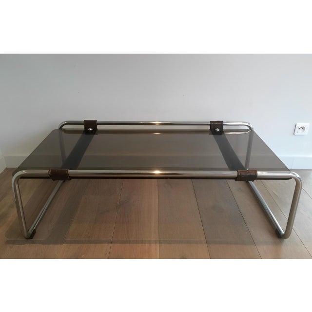 This rare and very unusual coffee table is made of a chrome base with a wide leather band and a smoked glass top. This is...