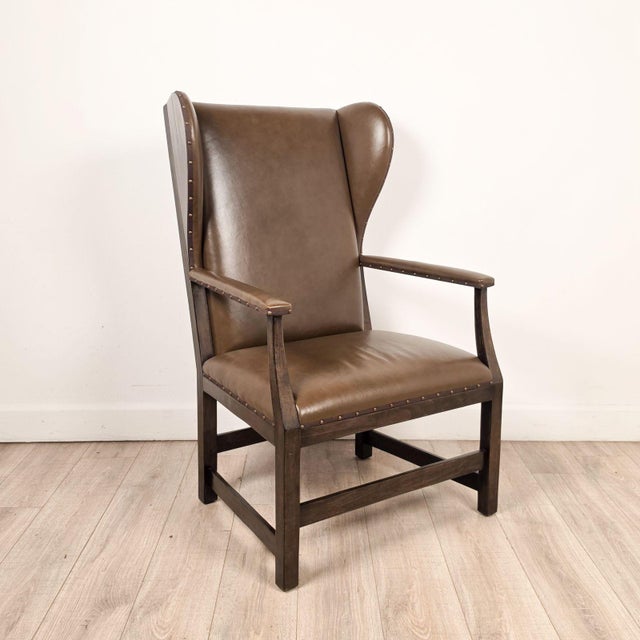 A bespoke wing chair Dover by Gregorius Pineo with olive green leather and hardware frame, circa 1980. Seat height 19".