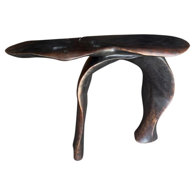 A beautiful reclaimed piece of mahogany wood is hand carved into a sculptural console table or desk. This impressive one...