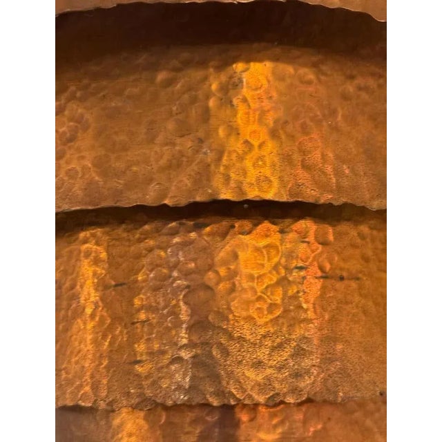 A handcrafted, layered wall sconce in hammered copper with a warm patina. The stepped design diffuses light beautifully,...