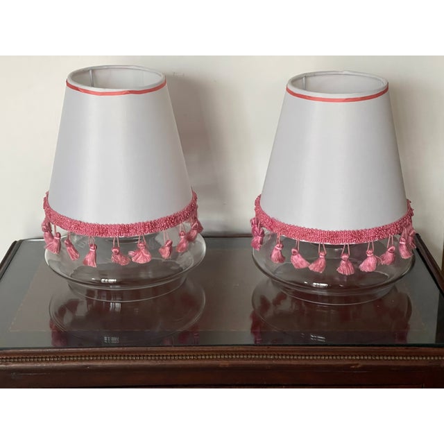 Pair of white lamp shades 7” by 7” with hot pink fringes.