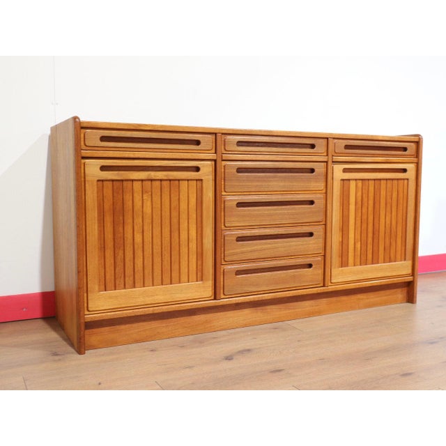 A stunning credenza in the style of renowned Danish furniture maker Dyrlund, this Mid Century Modern Vintage Teak Danish...