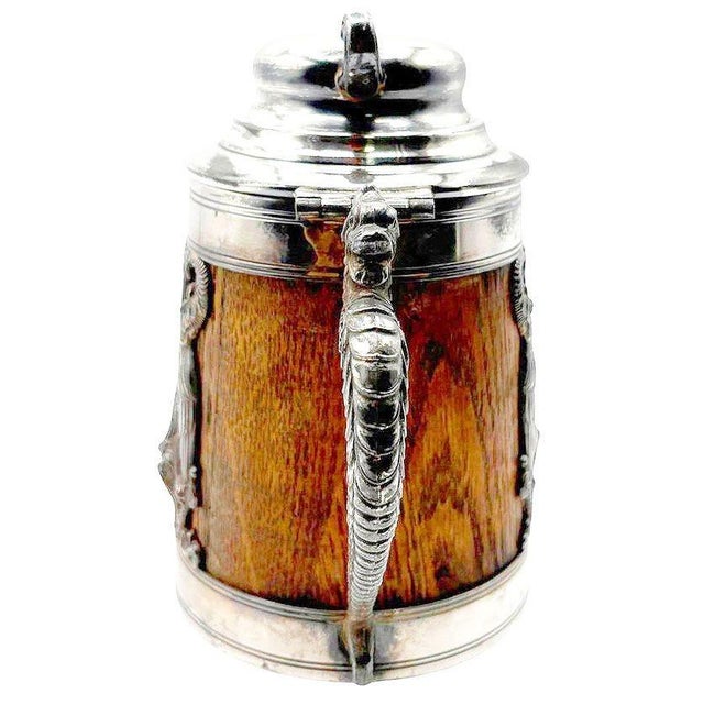 A striking antique beer stein by the St. Louis Silver Company, combining an Oak tankard shape with silver-plated mounts....