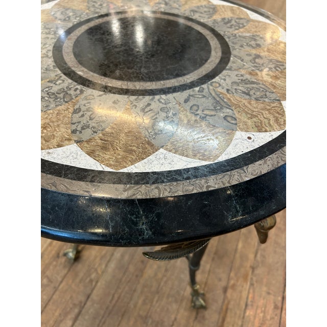Elegant inlaid mixed marble top round side table in earth colors with central black circle, having gorgeous swan motif...