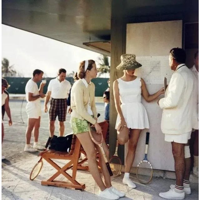 Tennis In The Bahamas 1957 by Slim Aarons Slim Aarons Limited Estate Edition Two women stand talking to a man on the edge...