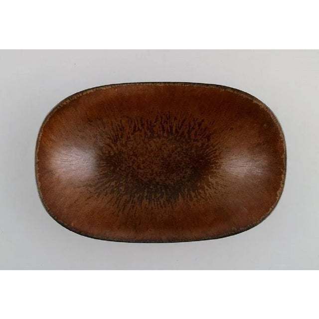 Gunnar Nylund for Rörstrand. Bowl in glazed ceramics. Beautiful glaze in brown shades. Mid-20th century Measures: 17 x 11...