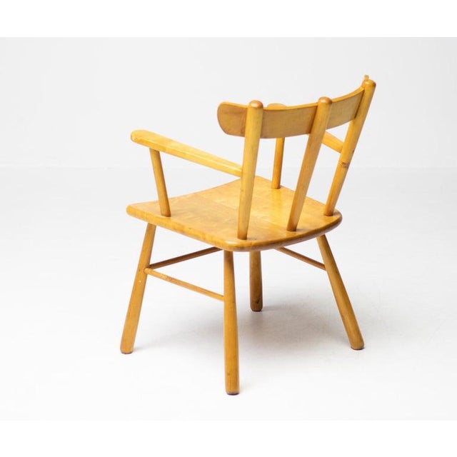 Beautiful, organic and natural armchair in solid honey colored birch. A simplistic design with a round seating and...