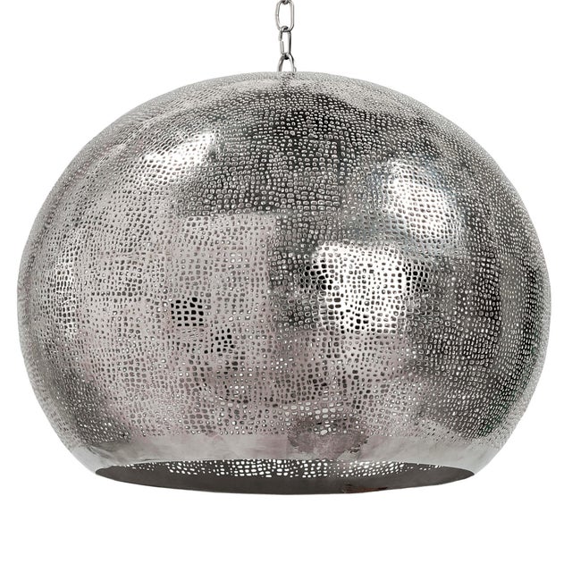 Handcrafted with a brilliant polished nickel finish and an organic perforated design this pierced metal sphere pendant is...