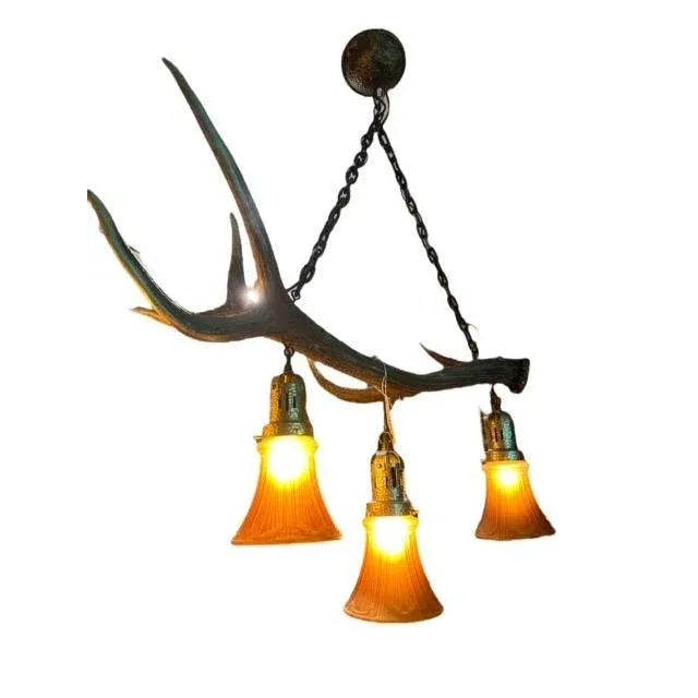 A 1950s German antler chandelier with new glass shades — rustic alpine lighting for a chalet or lodge. Wiring is as-is....