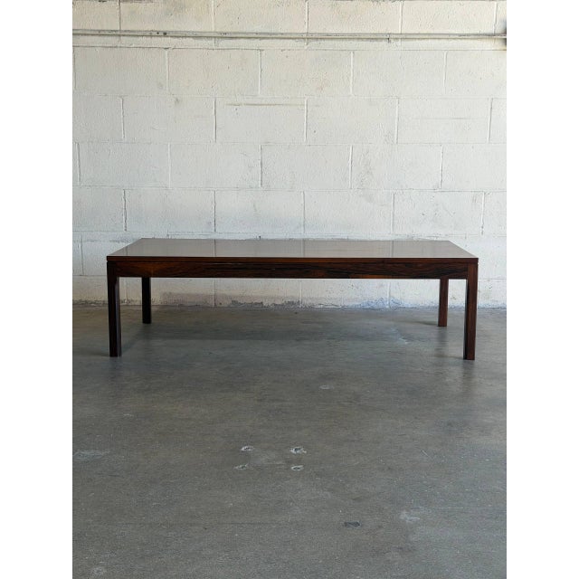 Danish Mid-Century Modern coffee table crafted in rich rosewood, showcasing stunning natural grain and timeless...