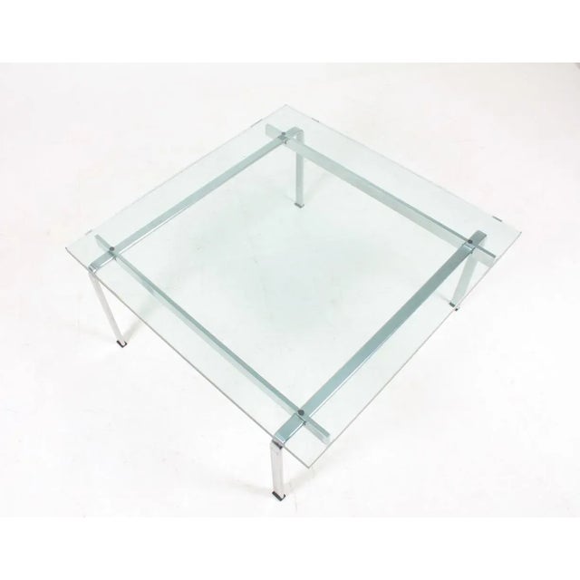 Low table with glass top on a stainless steel base. Designed by Maa. Jørgen Fabricius & Preben Kastholm for Kill...