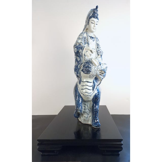 Large Chinese blue and white porcelain seated Kuan Yin/Buddha on a qilin, seated in a pose of ease on a lotus throne atop...