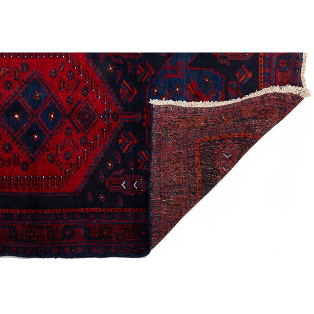 Handcrafted by tribal Kurdish artisans, this striking vintage wool runner rug features a rich, deep palette dominated by...
