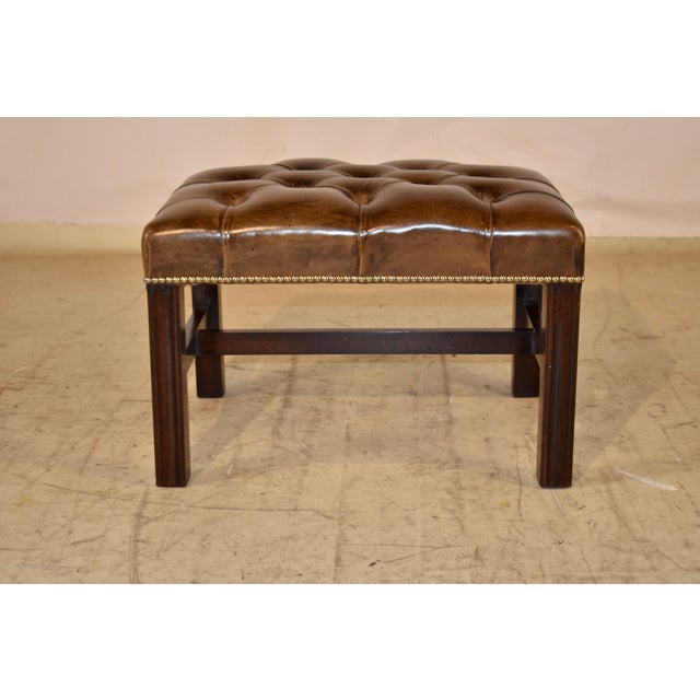 Circa 1920's Edwardian stool from England. the seat is upholstered in rich brown tufted leather, finished with brass...
