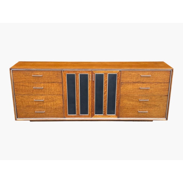 This exceptional Mid-Century Modern walnut credenza combines refined craftsmanship with a bold architectural presence....