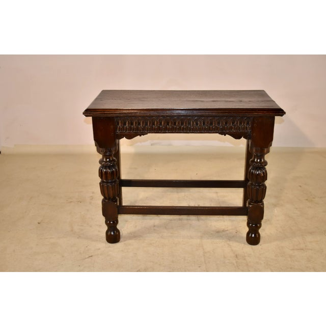 18th century oak console table from England. The top has a beveled edge, following down to a hand carved apron with...