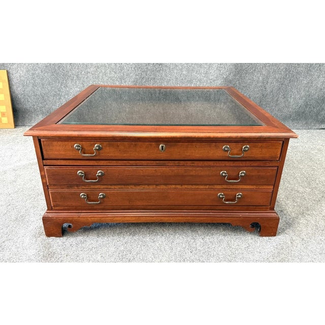 This Hooker Furniture curio coffee table features a glass display top, rich wood finish, and multiple drawers that offer...