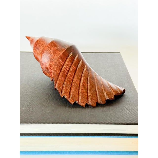 Lovely pair pf heavy vintage coastal conch shell sculptures carved from Ironwood. Beautiful gleaming rich tone to the wood...