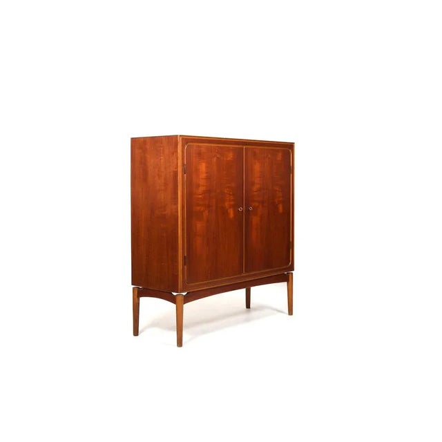 Fine Danish teak and birch wooden cabinet / cupboard. Denmark, 1950s. with two doors. Inside with shelfes and drawers....