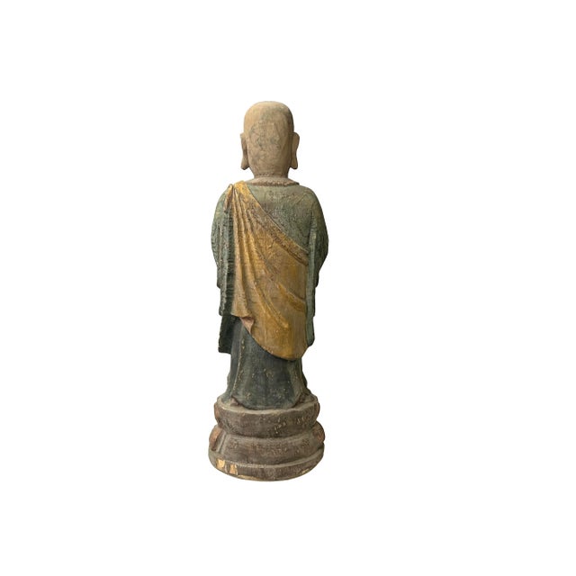 This Chinese rustic wooden statue, featuring a standing Lohon monk with prayer hands, exudes a serene and meditative...