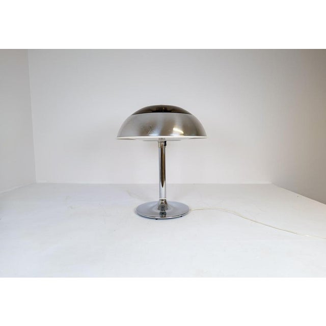 This large, chromed table lamp was manufactured at Fagerhults Belysning in Sweden, 1970s. The shade is in chromed metal...