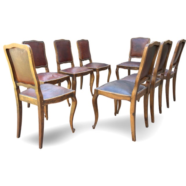 Presenting eight Louis XV dining chairs from the late 1800s. These antique chairs feature elegant walnut frames...