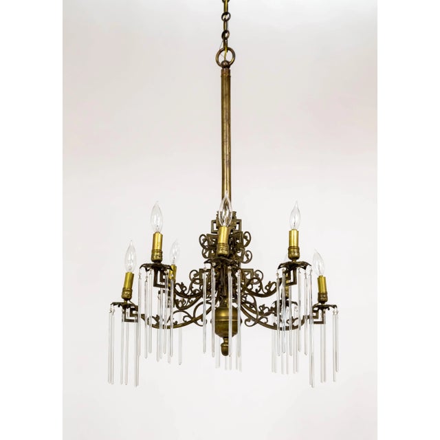 An 1880s, formerly candle-lit chandelier, newly electrified. A fully brass structure with a rich patina and ornate brass...