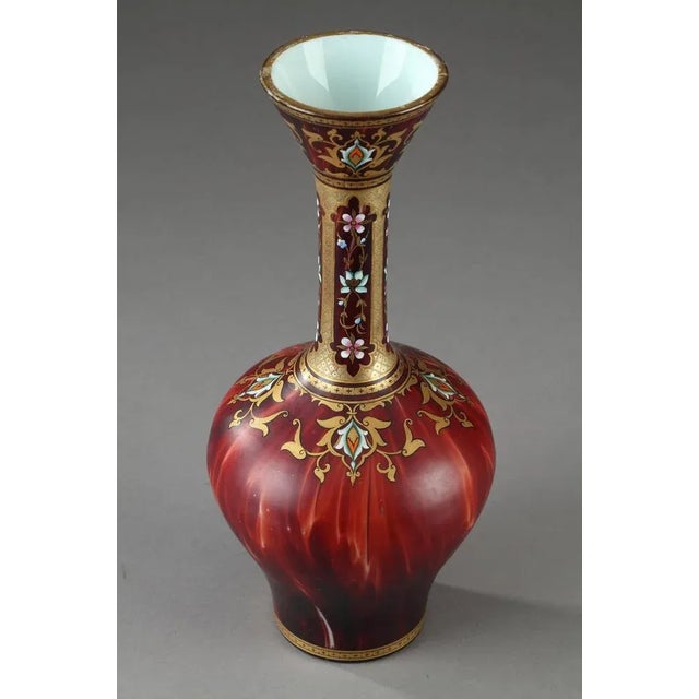 Bulb-bottomed vase with long neck decorated with multicolored enamel and gold. It is embellished with arabesques, flowers...