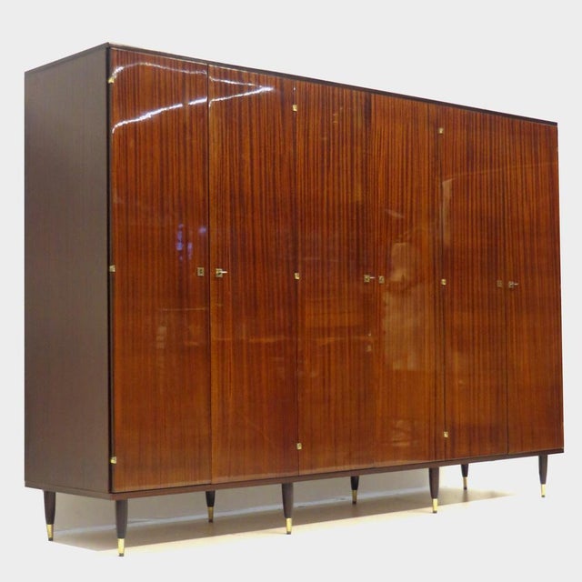 Vintage mid century modern 6-door wardrobe in teak from the 1960s. This large wardrobe rests on eight stylish legs with...