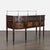 This elegant sideboard features a wood finish with burl veneer, decorative metal inlays, ornate drawer fronts and top, and...