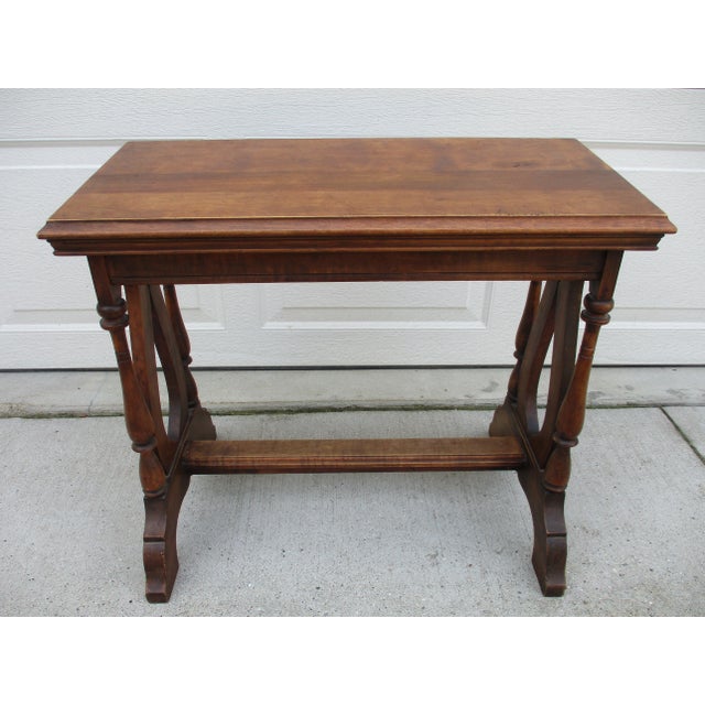 This wonderful side table with harp-like side supports has a slightly angled top, likely to display an open book or sheets...