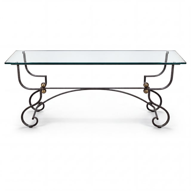 This is a mid-century French neoclassical style wrought iron console table with a glass top. It has a scrolled base with...