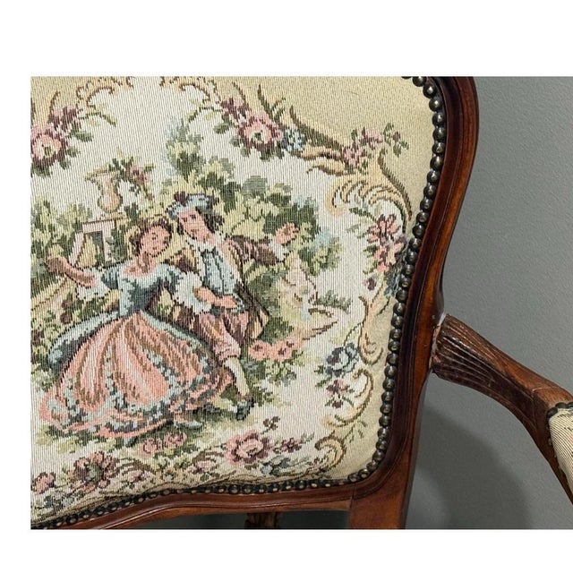 This chair is a Louis XV-style tapestry armchair, a high-quality 20th-century vintage reproduction of a classic 18th-...