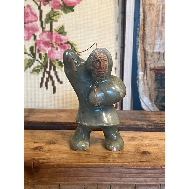 This pacific north west style carved stone indigenous Hunter is depicted spear fishing. Has chips consistent with age....