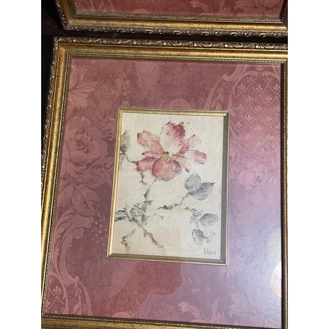 Beautiful set of two vintage floral framed prints featuring soft botanical artwork, accented by ornate gold-tone gilt...