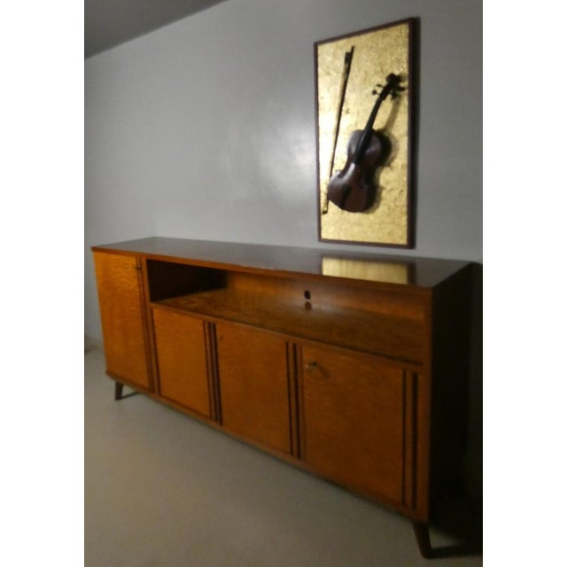 Sideboard in massive teak handcrafted in the 70s in Italy. The weekly compartment (with 7 drawers, of which the last lower...