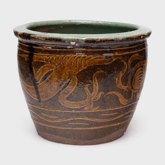 Originally used for pickling and food preservation, this 19th-century ceramic pot is decorated with two serpentine dragons...