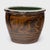 Originally used for pickling and food preservation, this 19th-century ceramic pot is decorated with two serpentine dragons...