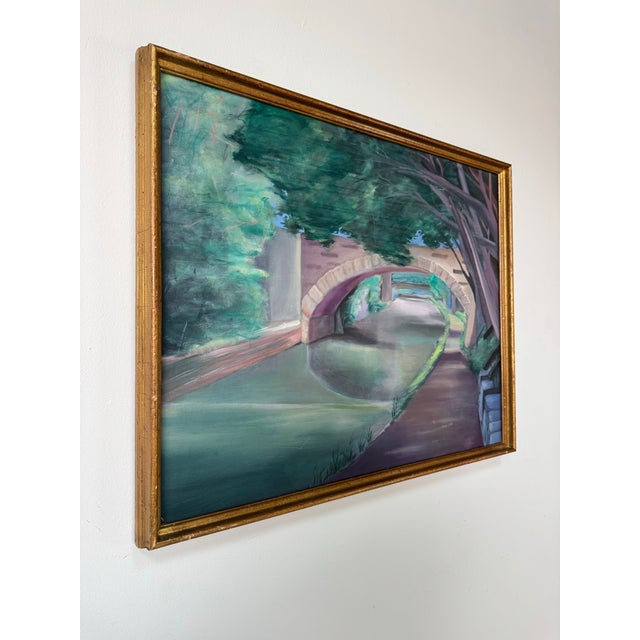 Vintage 1980’s original oil on canvas painting by artist Eric Lewis, depicting a serene canal scene framed by a graceful...